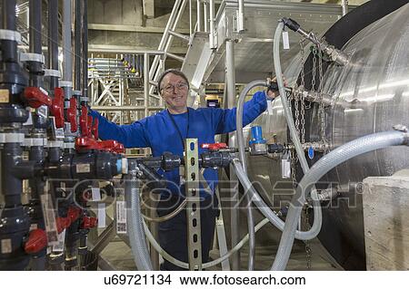 Picture - Water department engineer standing in treatment injection room.. Fotosearch