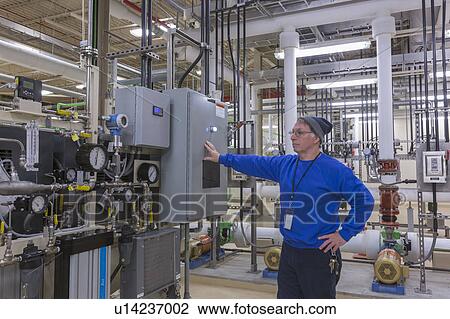 Stock Image - Water department engineer standing in chemical treatment room.. Fotosearch