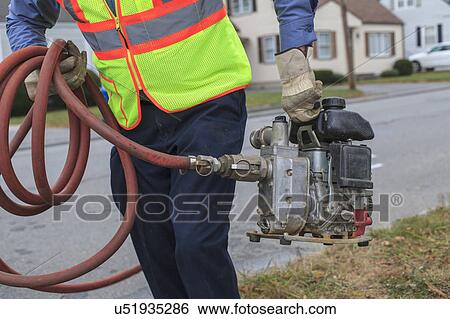 Water department technician carrying gasoline powered pump for flushing hydrants. View Large Photo Image Stock Photograph - Water department technician carrying gasoline powered pump for flushing hydrants.. Fotosearch