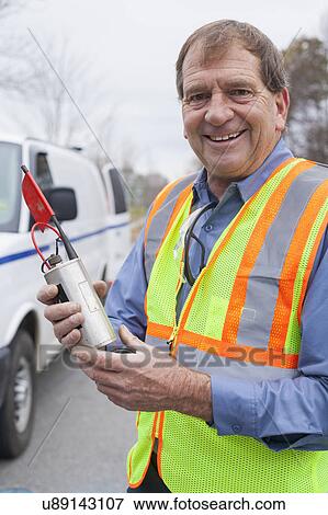 Water department technician holding leak sensor. View Large Photo Image Stock Photo - Water department technician holding leak sensor.. Fotosearch