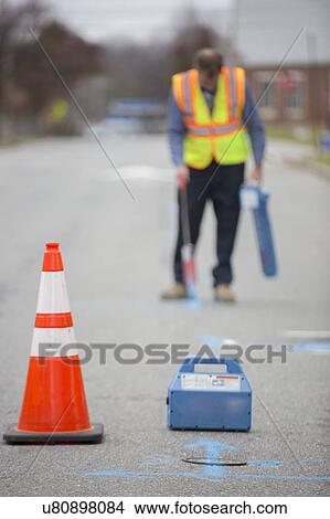 Water department technician marking underground location of water pipes. View Large Photo Image Picture - Water department technician marking underground location of water pipes.. Fotosearch