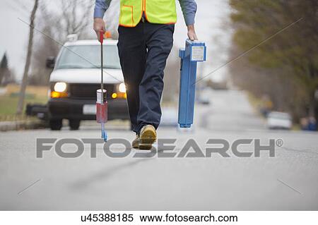 Stock Photography - Water department technician marking underground location of water pipes.. Fotosearch