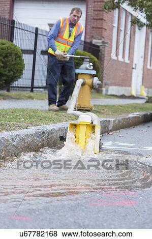 Stock Photo - Water department technician opening fire hydrant to flush water mains.. Fotosearch