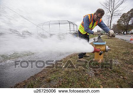 Water department technician opening fire hydrant to flush water pipes. View Large Photo Image Stock Photograph - Water department technician opening fire hydrant to flush water pipes.. Fotosearch
