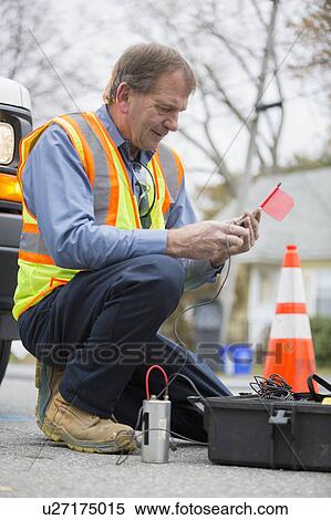 Stock Photography - Water department technician using flow rate sensor.. Fotosearch