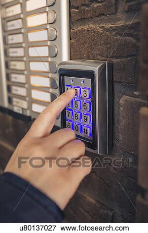 Stock Photo - Woman entering passcode on security keypad. Fotosearch