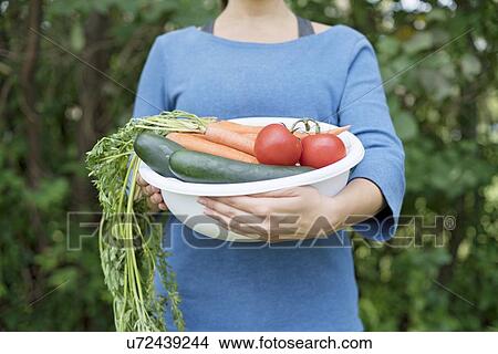 Woman holding bowl with fresh vegetables. View Large Photo Image Picture - Woman holding bowl with fresh vegetables.. Fotosearch