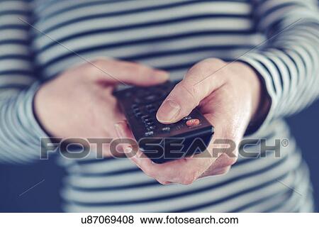 Woman holding remote control View Large Photo Image Stock Photo - Woman holding remote control. Fotosearch