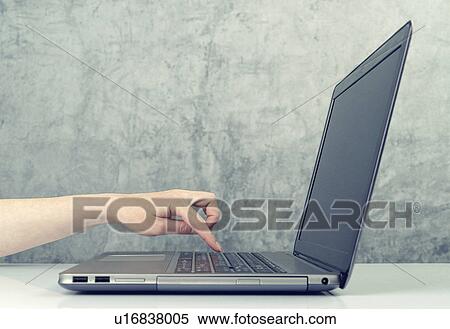 Stock Photography - Woman pressing keypad on laptop computer. Fotosearch