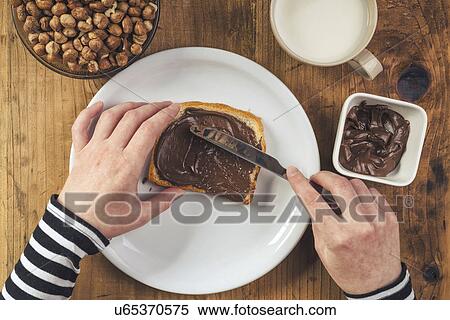 Woman spreading chocolate hazelnut spread on bread View Large Photo Image Stock Photography - Woman spreading chocolate hazelnut spread on bread. Fotosearch