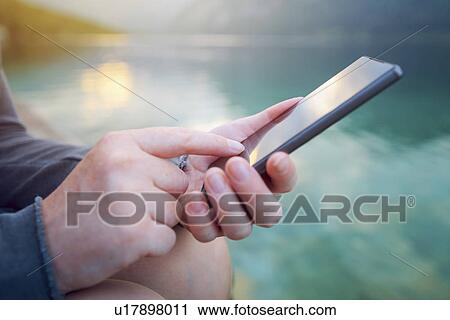 Woman using smartphone outdoors View Large Photo Image Stock Image - Woman using smartphone outdoors. Fotosearch