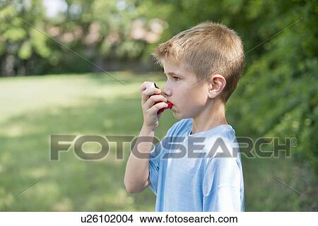 Young boy using an inhaler. View Large Photo Image Picture - Young boy using an inhaler.. Fotosearch