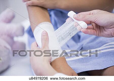 Young girl having bandage applied to arm. View Large Photo Image Stock Photograph - Young girl having bandage applied to arm.. Fotosearch