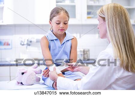 Stock Photography - Young girl having bandage applied to arm.. Fotosearch