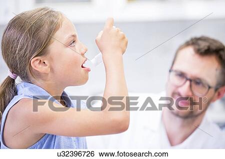 Young girl using inhaler with doctor watching. View Large Photo Image Stock Photograph - Young girl using inhaler with doctor watching.. Fotosearch