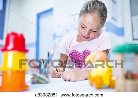 Stock Image - Young girl with colouring pencils, smiling.. Fotosearch