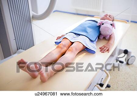 Stock Image - Young girl with teddy having an x-ray.. Fotosearch