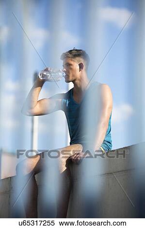 Young man drinking bottle of mineral water. View Large Photo Image Stock Photography - Young man drinking bottle of mineral water.. Fotosearch