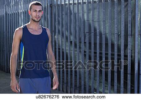 Stock Photograph - Young man in blue vest, portrait.. Fotosearch