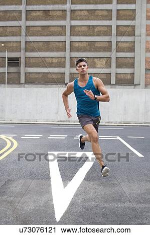 Young man running on road. View Large Photo Image Stock Image - Young man running on road.. Fotosearch