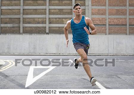 Young man running on road. View Large Photo Image Stock Image - Young man running on road.. Fotosearch