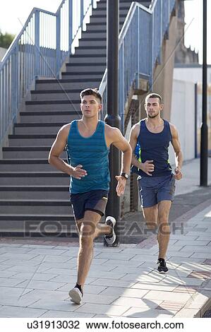 Stock Image - Young men running past steps.. Fotosearch