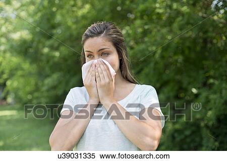 Young woman blowing her nose on a tissue. View Large Photo Image Stock Photography - Young woman blowing her nose on a tissue.. Fotosearch
