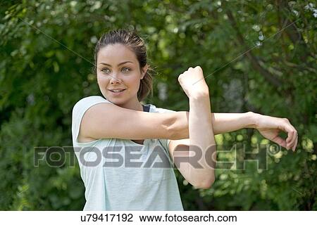 Stock Image - Young woman stretching before exercise.. Fotosearch