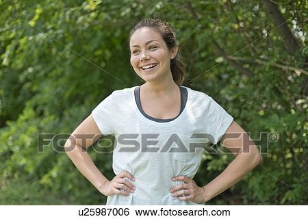 Young woman with hands on hips, smiling. View Large Photo Image Stock Photograph - Young woman with hands on hips, smiling.. Fotosearch