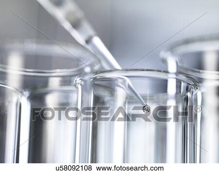 Stock Photo - A pipette placing a sample into a test tube during a experiment in the laboratory.. Fotosearch