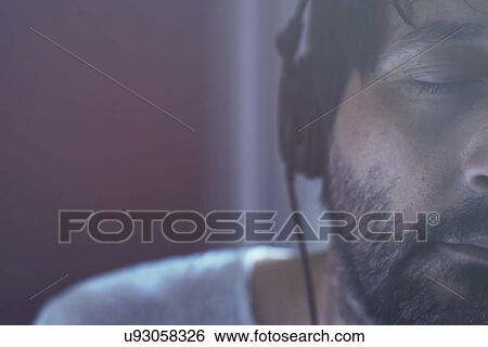 Adult man listening to music on headphones. View Large Photo Image Stock Photograph - Adult man listening to music on headphones.. Fotosearch