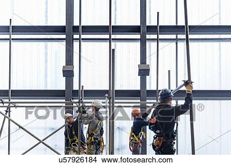 Picture - Apprentice engineers preparing and setting up scaffolding. Fotosearch