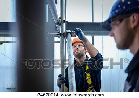 Picture - Apprentice engineers preparing and setting up scaffolding. Fotosearch