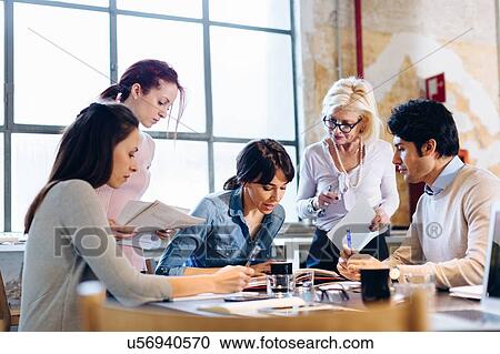 Stock Image - Architects going through documents together. Fotosearch