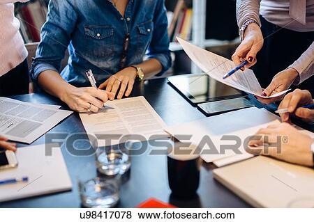 Stock Photo - Architects going through documents together. Fotosearch