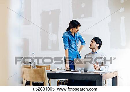 Stock Photography - Architects having discussion at laptop. Fotosearch