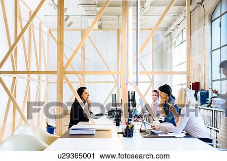 Architects having discussion at workstations View Large Photo Image Stock Image - Architects having discussion at workstations. Fotosearch
