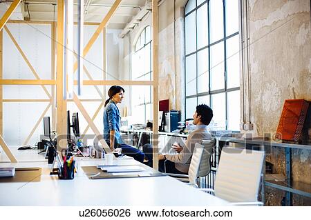 Stock Photograph - Architects having discussion at workstations. Fotosearch