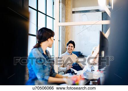 Architects having discussion at workstations View Large Photo Image Stock Photograph - Architects having discussion at workstations. Fotosearch