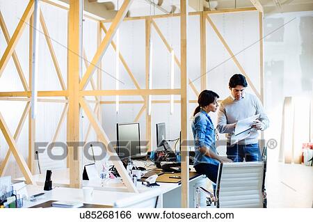 Stock Photograph - Architects having discussion at workstations. Fotosearch