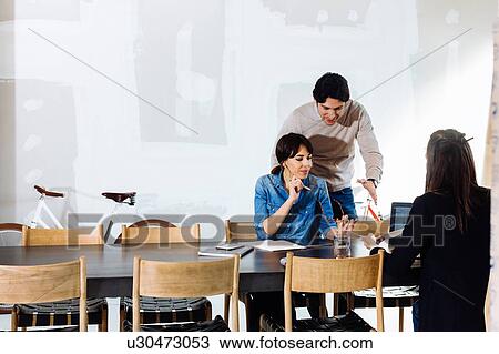 Stock Image - Architects working at meeting table. Fotosearch