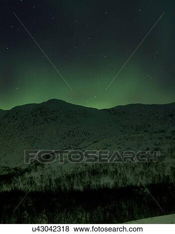 Aurora borealis over snow covered hills at night, Finnmark, Norway View Large Photo Image Stock Photo - Aurora borealis over snow covered hills at night, Finnmark, Norway. Fotosearch