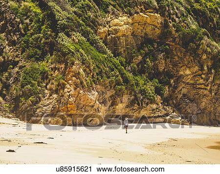 Australia, New South Wales, Bermagui, Woman walking along beach View Large Photo Image Stock Image - Australia, New South Wales, Bermagui, Woman walking along beach. Fotosearch