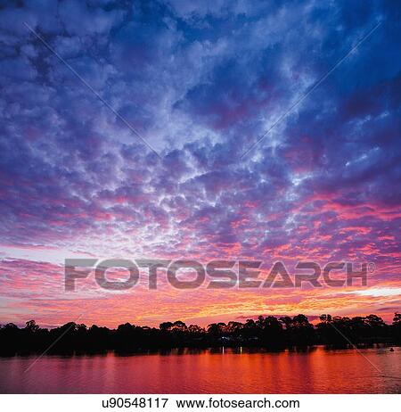 Stock Photo - Australia, New South Wales, Bermagui, Scenic sunset above water. Fotosearch