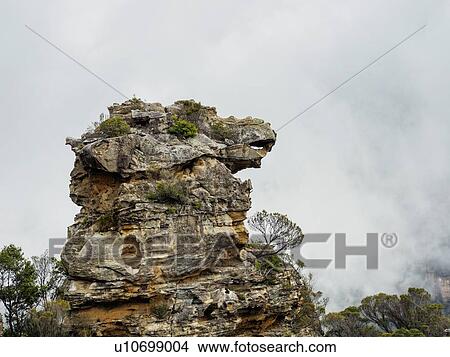 Picture - Australia, New South Wales, Katoomba, Large rock and cloudy sky behind. Fotosearch