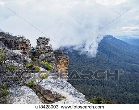 Australia, New South Wales, Katoomba, Large rocks and mountains in clouds View Large Photo Image Stock Image - Australia, New South Wales, Katoomba, Large rocks and mountains in clouds. Fotosearch