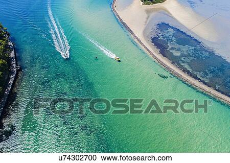 Stock Image - Australia, New South Wales, Narooma, Aerial view of speedboats and inlet. Fotosearch