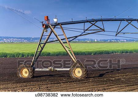 Stock Image - Automated farming irrigation sprinklers.. Fotosearch