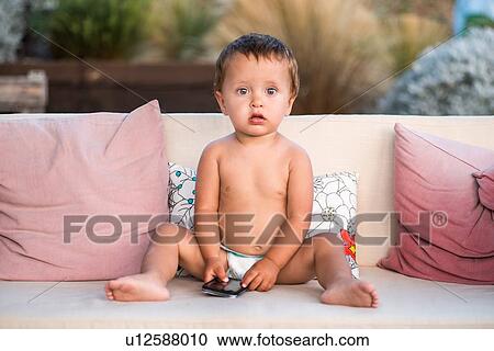 Baby boy holding smartphone looking at camera View Large Photo Image Stock Image - Baby boy holding smartphone looking at camera. Fotosearch