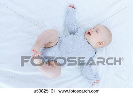 Stock Image - Baby boy lying on back.. Fotosearch